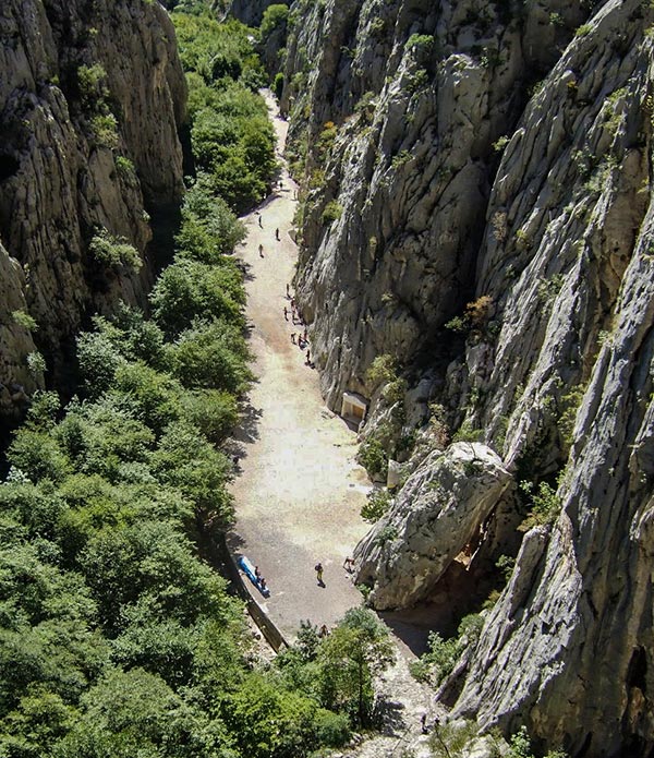 The view of Klanci from halfway up on Debeli Kuk looking towards the entrance of the park. Climbers can be found on the right next to the rock wall and hidden under the trees on the left!