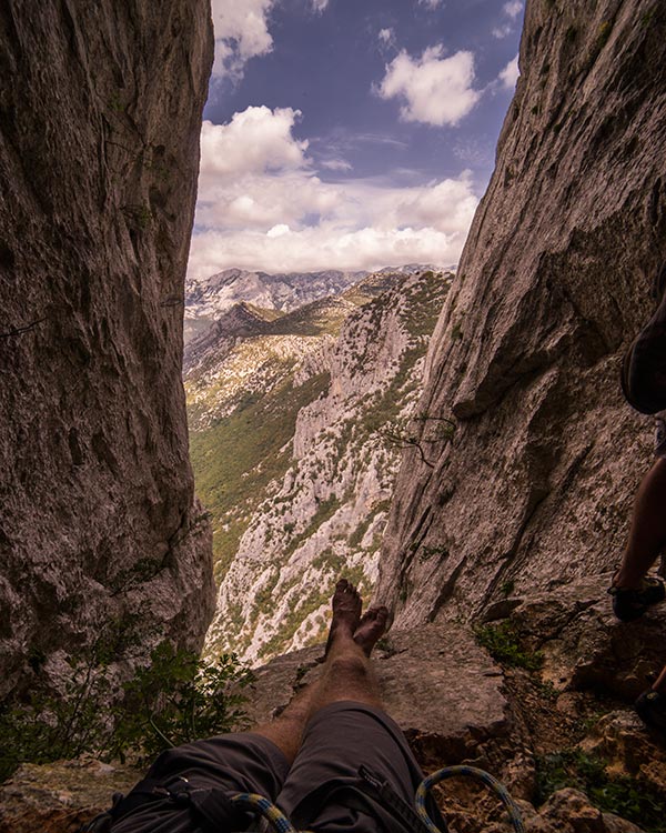 Relaxing a comfy belay ledge located in a cave high up on Velebitaški.