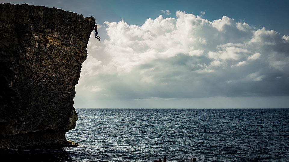 Flying high above the Atlantic on El Arete Libre 5.10a near Arecibo, Puerto Rico!