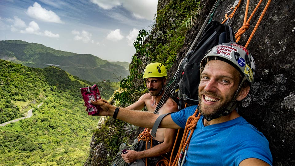 Will and I cheers'ing sangria pouches to a good climb and enjoying the views of the tropical mountains near Cayey in Cerro Las Tetas!